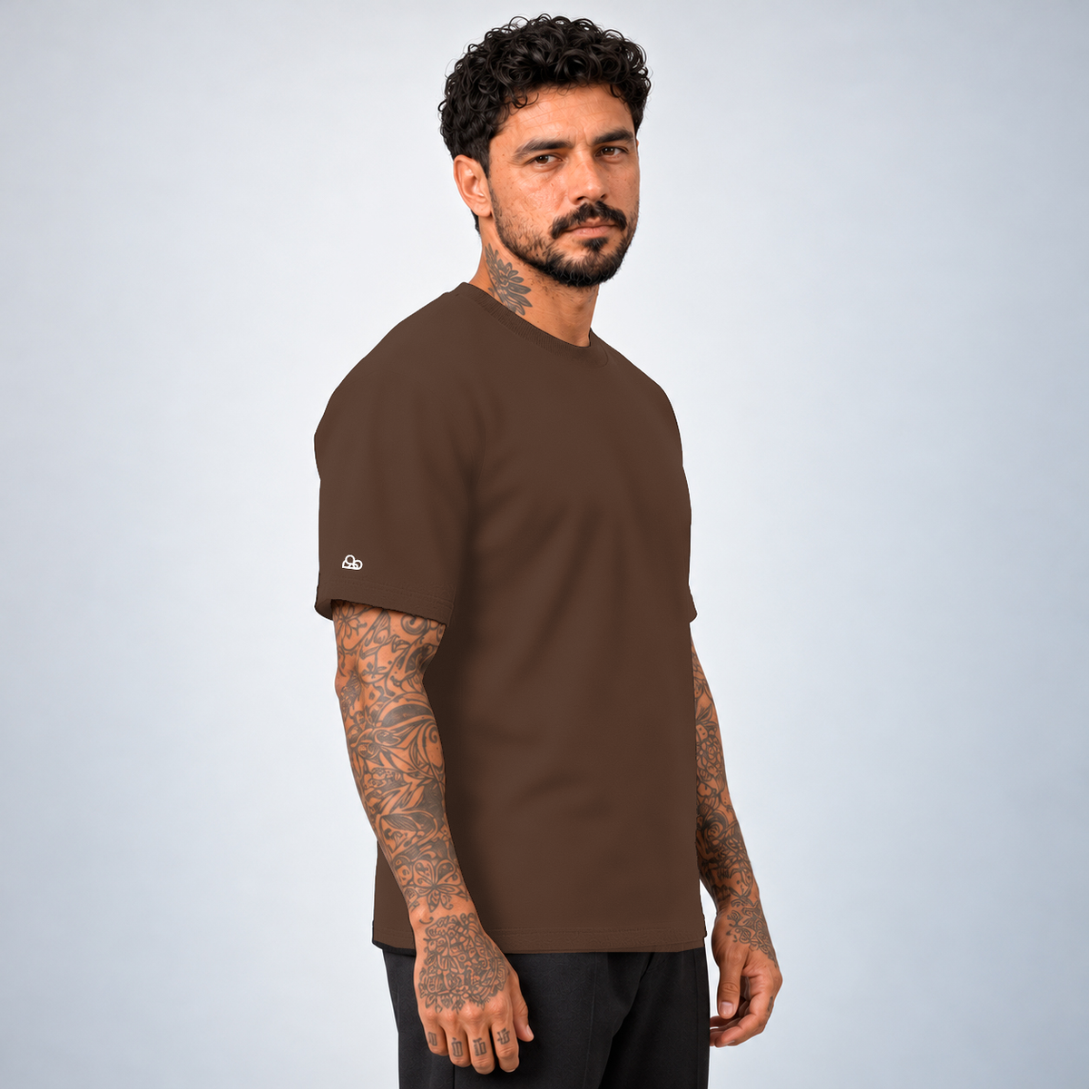Camiseta Basic WNC Lisa Marrom, vista lateral no modelo com nuvem na manga