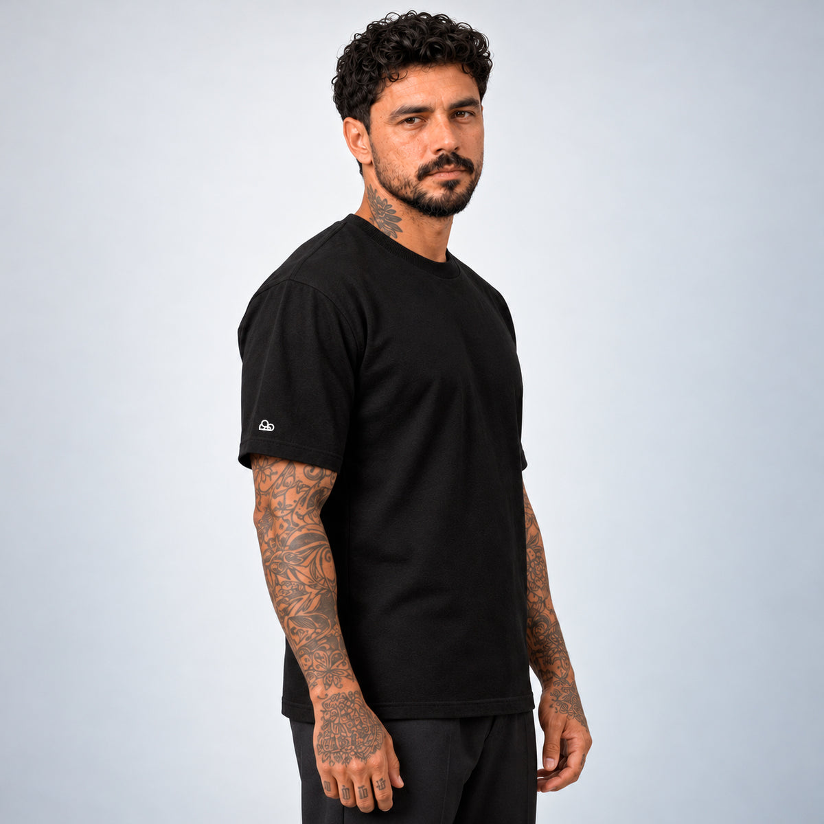 Camiseta Basic WNC Lisa preta no modelo, vista lateral com logo de nuvem na manga