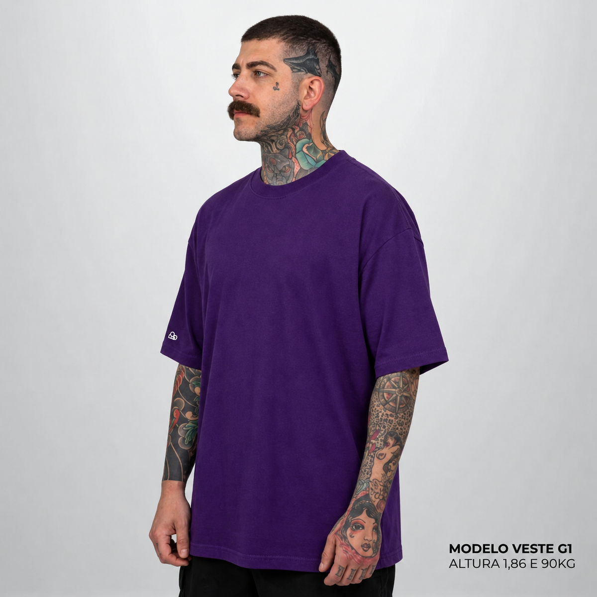 Camiseta Oversized WNC Lisa Roxo em vista lateral, com o modelo de bigode do ensaio original da cor. Imagem complementar gerada digitalmente.